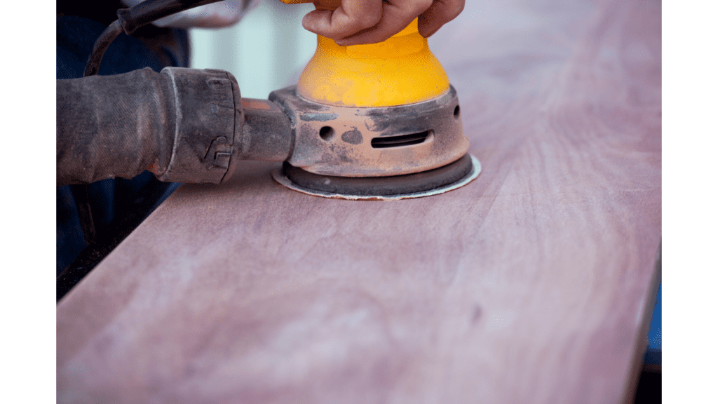 A man sanding and upcycling pine  furniture